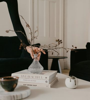 mise en place de décorations sur une table basse avec petit vase et libres tendances