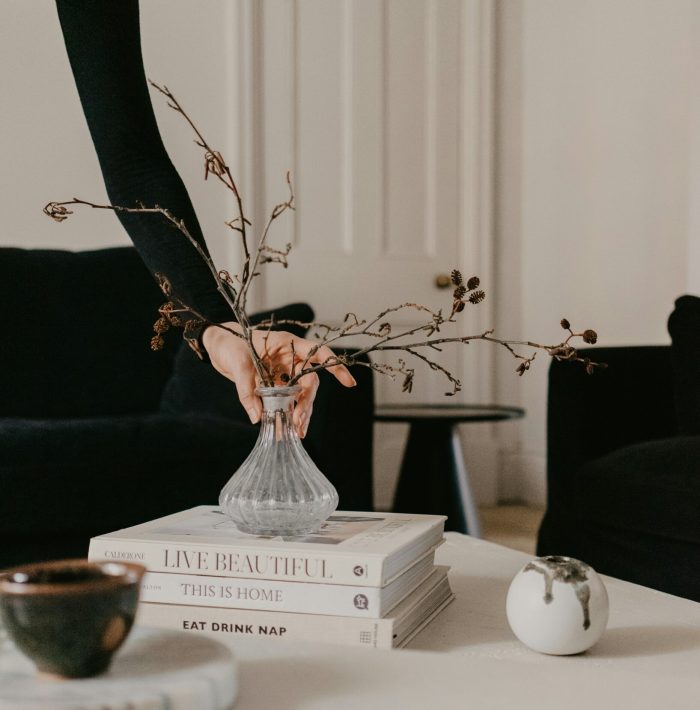 mise en place de décorations sur une table basse avec petit vase et libres tendances